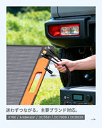 A person holding the universal DC charging cables connected to a portable power station next to a white off-road vehicle.